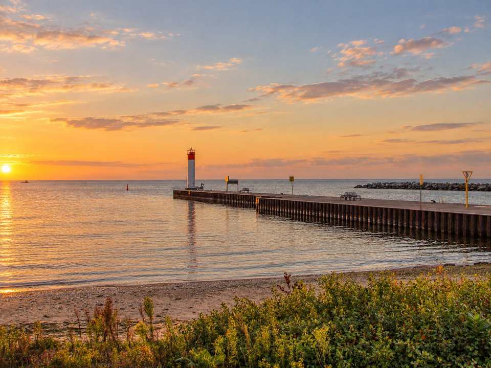The Whitby Harbour lighthouse at the end of its pier on Lake Ontario, on a summer evening